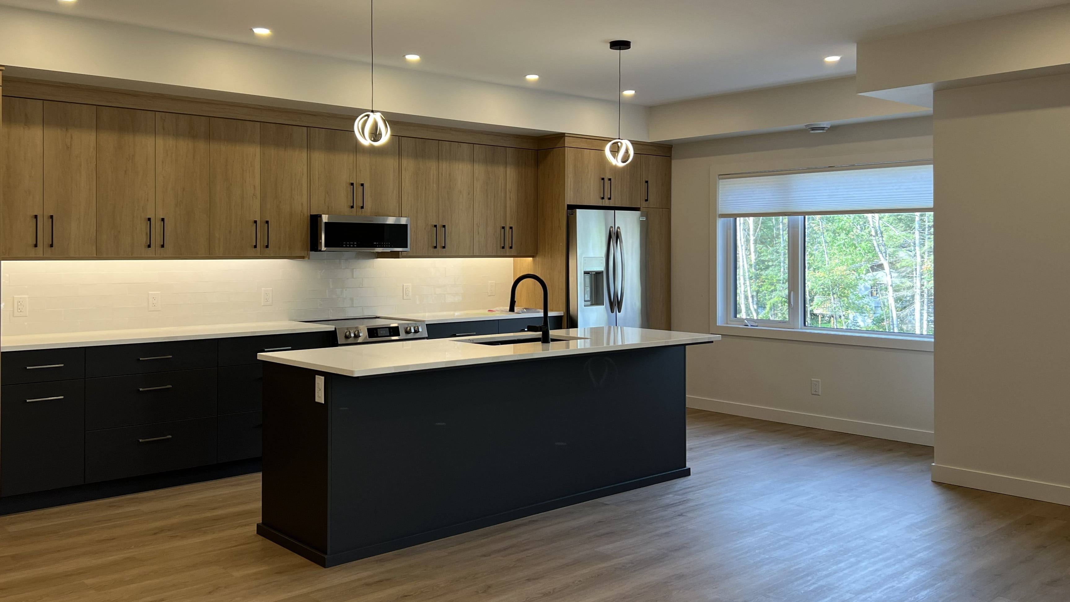 Open concept kitchen with island, quartz counters and stainless appliances